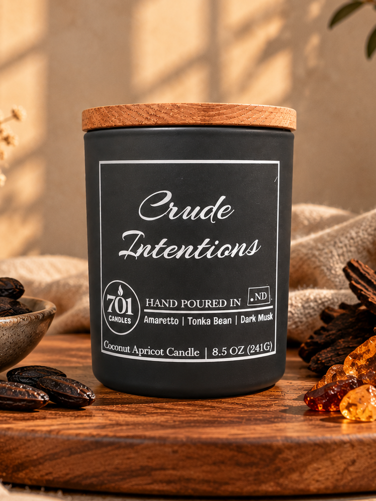 Crude Intentions candle in a matte-black ceramic vessel with an engraved wooden lid.