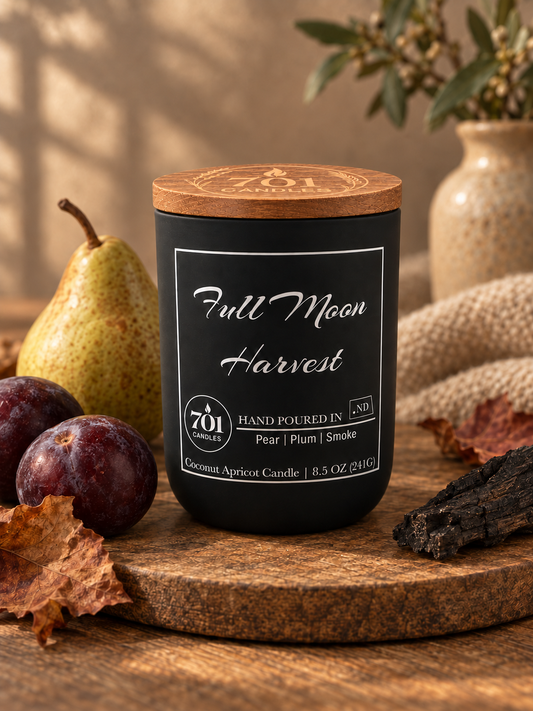 Full Moon Harvest candle in a matte-black ceramic vessel with an engraved wooden lid.