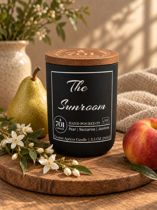 The Sunroom candle in a matte-black ceramic vessel with an engraved wooden lid.